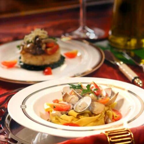Coques et moules à la mangue et au lait de coco sur un lit de spaghetti